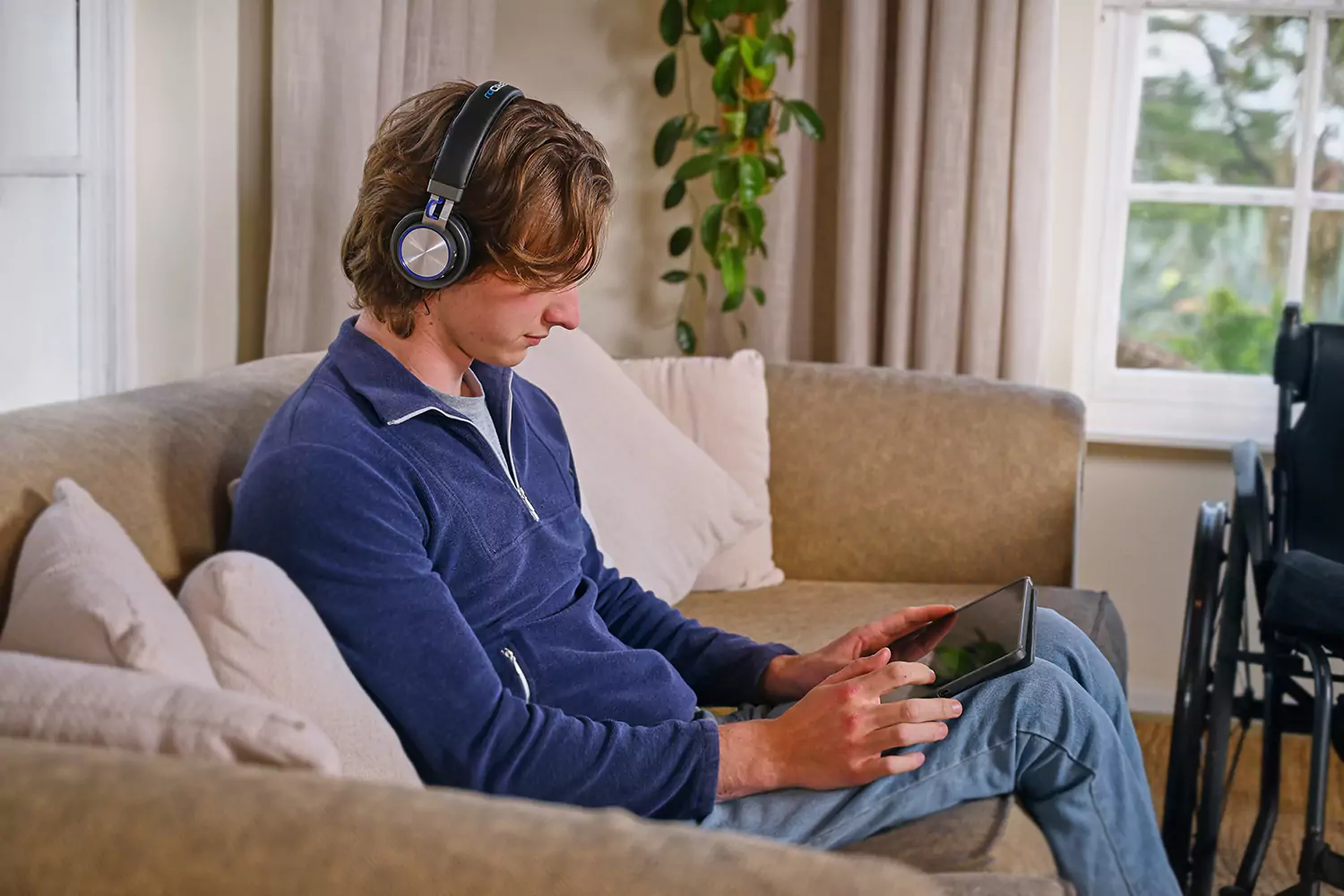 A young man sitting indoors is using his laptop to contact Farr & Beyond